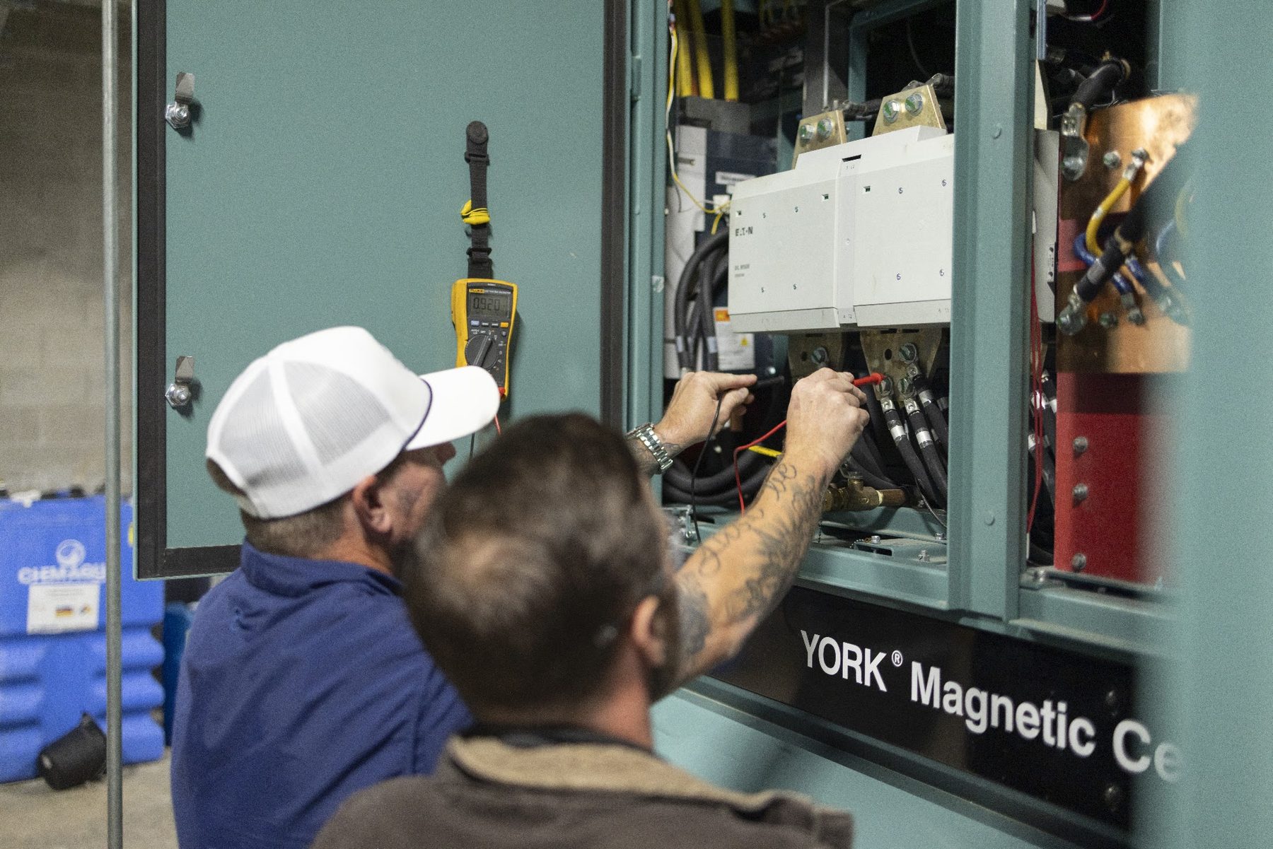 Augusta Chiller Service technicians testing a chiller control cabinet
