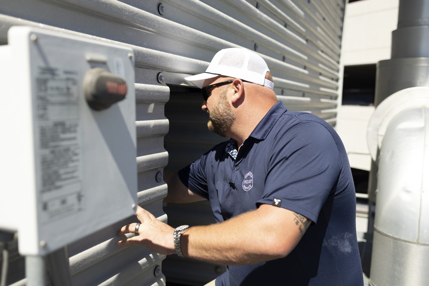 Technician troubleshooting a rooftop HVAC unit
