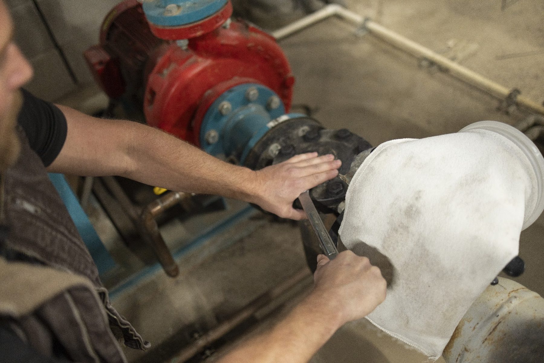 Technician servicing a valve on commercial chilled water piping